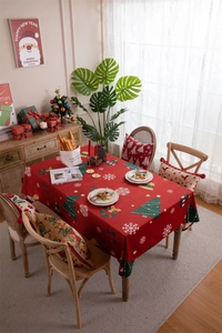Festive red Christmas tablecloth with snowflake and tree patterns in warm home setting