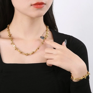 Fashionable gold titanium steel knotted chain necklace and bracelet set on a model