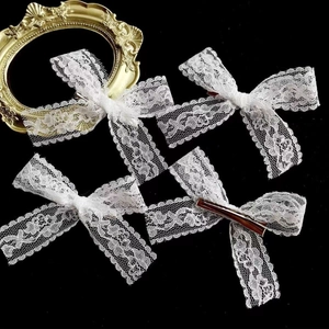 Detail of white lace bow hair clip with vintage frame on black background