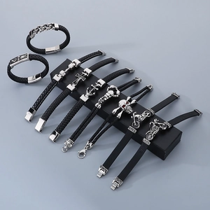 Close-up of men's leather bracelets with skull, anchor, and cross stainless steel charms