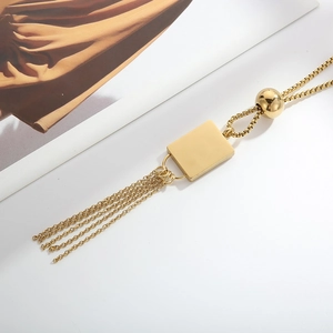 Detail of 18K gold-plated necklace with rectangular pendant and elegant chain tassels