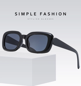 Close-up of stylish black square frame sunglasses on a minimalist white display