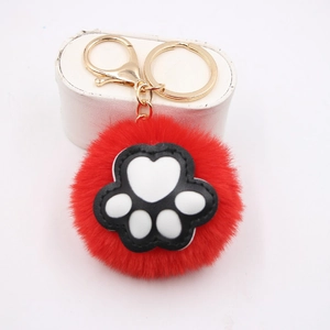 Red fluffy pom pom keychain with cute black and white cat paw print and gold clasp