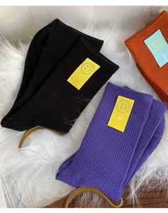 Détail de chaussettes côtelées en coton avec patchs sourire sur fourrure blanche