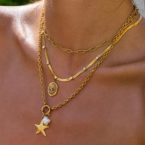 Three-layer gold necklace set with portrait medallion, star, and baroque pearl detail