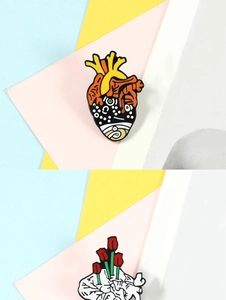Detail of anatomical heart enamel pins with surreal tulips on a colorful background