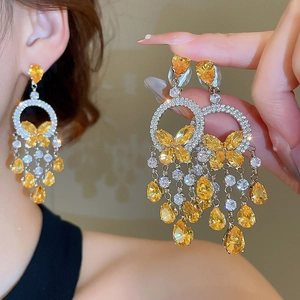 Detailed close-up of butterfly tassel earrings with silver needles and yellow gemstones