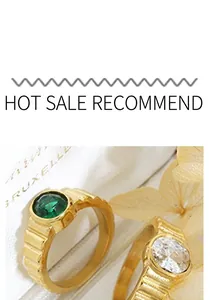 Detail of gold-plated rings featuring large emerald green and clear white gemstones