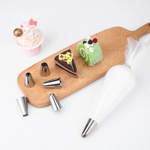 Stainless steel cake piping nozzles set with pastry bag and decorated cupcakes on tray