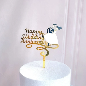 Golden acrylic cake topper featuring dancing figures for wedding anniversary