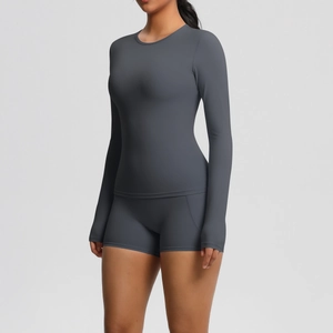Détail du haut de yoga gris à manches longues avec passe-pouces et short de sport