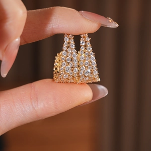 Vista macro di orecchini a U placcati oro 18k con pavé di zirconi scintillanti