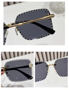 Detail of rimless square sunglasses with grey lenses and gold moon accents on frame