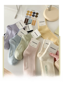 Detail of colorful macaron cotton socks with hello embroidery in a cozy lifestyle setting