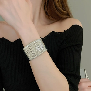 Detail of silver multi-layer twisted wire cuff bracelet on model wrist with elegant finish