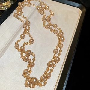 French retro layered pearl and yellow glass bead necklace on a beige velvet jewelry box