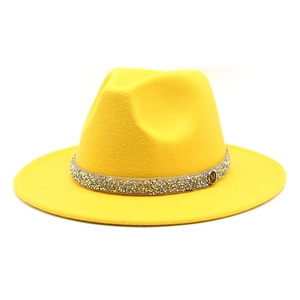 Detail of yellow wool fedora hat with rhinestone band and golden M metal emblem