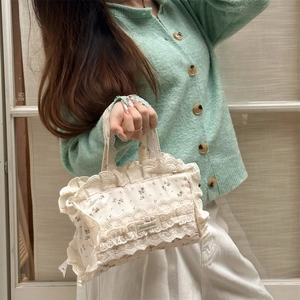 Gros plan sur un sac cabas en toile à fleurs avec des détails de dentelle blanche