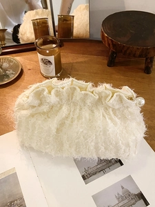 Pochette élégante en fausse fourrure blanc cassé avec perle dans un décor douillet
