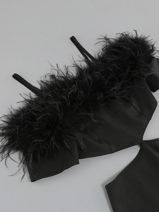 Detailed view of black off-shoulder neckline featuring premium feather trim and woven texture