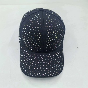 Top down detail of black cotton baseball cap covered in rows of colorful rhinestones