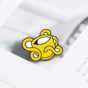 Macro shot of creative yellow enamel coffee cup brooch with sharp black outlines