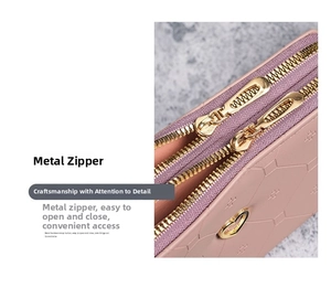 Close-up of light pink wallet featuring gold double zippers and heart pendants