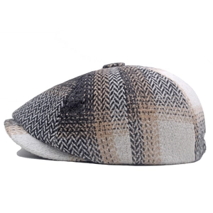 Detail view of winter newsboy hat with grey herringbone pattern and curved brim