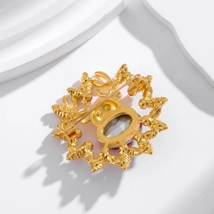 Back view of gold reindeer wreath brooch with red enamel and secure pin clasp