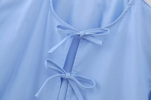 Nahaufnahme des blauen Puffärmel-Blusenausschnitts mit doppelten Schleifen und Schlitz