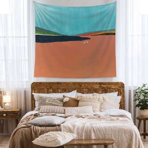 Artistic landscape tapestry with sunset orange and lake blue tones in a cozy bedroom