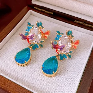 Gold plated butterfly drop earrings with colorful enamel and teardrop blue gemstones