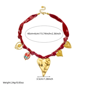 Red paisley fabric necklace with golden hammered heart and flower charms on white background