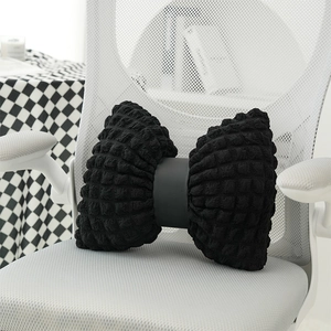 Creative black bow-shaped sofa cushion with textured fabric on a white office chair