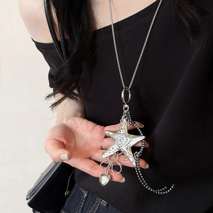 Macro view of silver starfish pendant necklace featuring spiral textures and woven cord