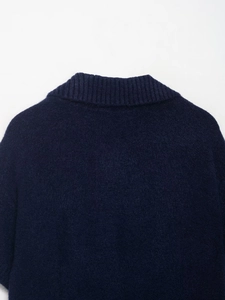 Close-up of navy blue rib-knit neckline showing soft fuzzy wool texture on a short sleeve sweater