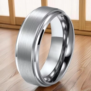 Minimalist silver titanium steel ring with brushed finish and polished edges on wood surface