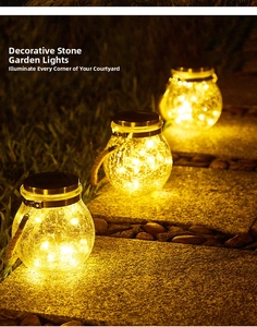 Close-up of solar crackle glass jar lights on stone tiles with warm LED copper wire glow