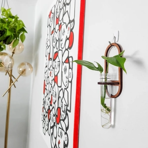 Close-up of wall-mounted wooden plant propagation station with clear test tube vase