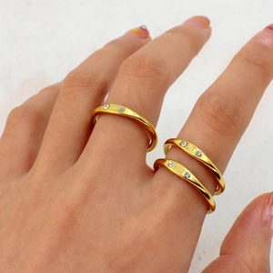 Detailed view of three gold-plated stainless steel zodiac rings with diamond accents