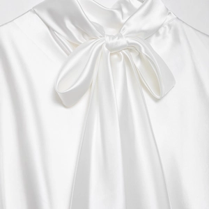 Elegante abito in raso bianco con raffinato dettaglio fiocco in seta sullo scollo