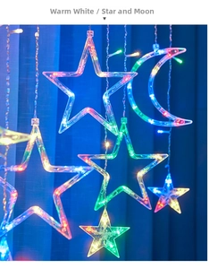 Detail of warm white LED curtain lights featuring hanging stars and moon shapes