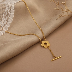Gold titanium flower pendant Y-necklace with bead chain and OT clasp on silk background