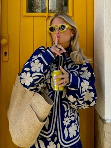 Dettaglio della giacca in cotone blu con ricamo floreale bianco e scollo rotondo casual