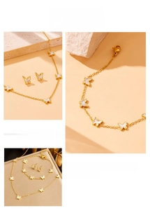 Detail of butterfly jewelry set with white shell inlay in polished gold finish