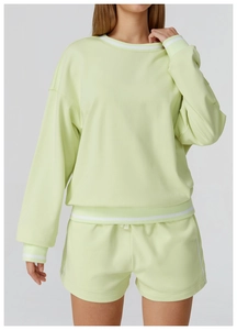 Détail de l'ensemble sweat vert clair avec bords-côtes rayés blancs aux poignets