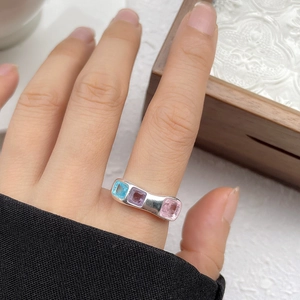 Detailed view of silver irregular ring featuring three square multi-colored gemstones