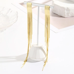 Detail of long gold tassel drop earrings with sparkling chain fringe on a silver stand