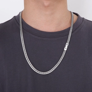 Close-up of a silver stainless steel curb chain necklace worn by a male model