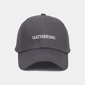 Détail de la broderie blanche GATHERING sur la casquette en sergé de coton gris foncé